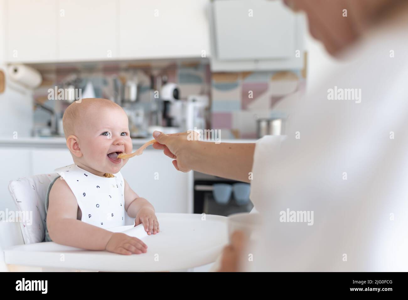 baby's first feeding, mom feeds a baby with a spoon Stock Photo Alamy