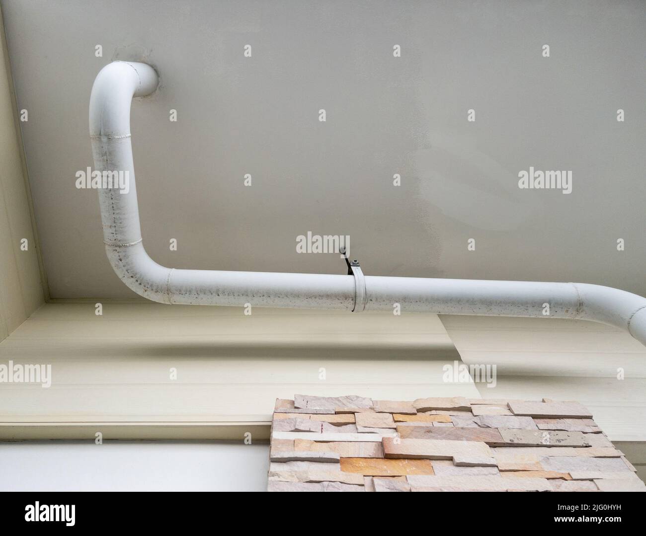 The white curve pipe for drainage of the air conditioner system is