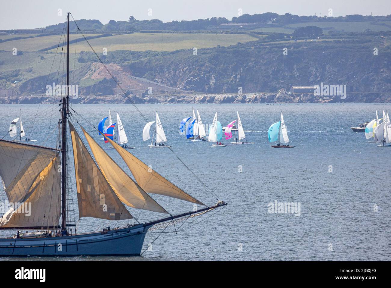 Classic sailing ship passes a fleet of Dragon yachts racing in Falmouth