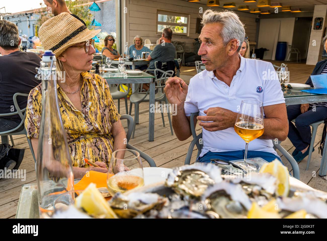 Florent Tarbouriech (r.) in conversation with food journalist Angela Berg at Le St Pierre Tarbouriech beach pavilion Stock Photo