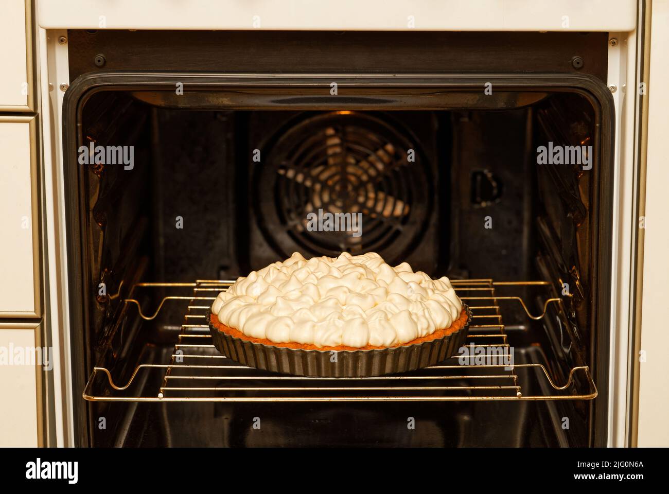 Closeup homemade berry pie decorated with meringue baked in a home oven. Shallow focus. Stock Photo