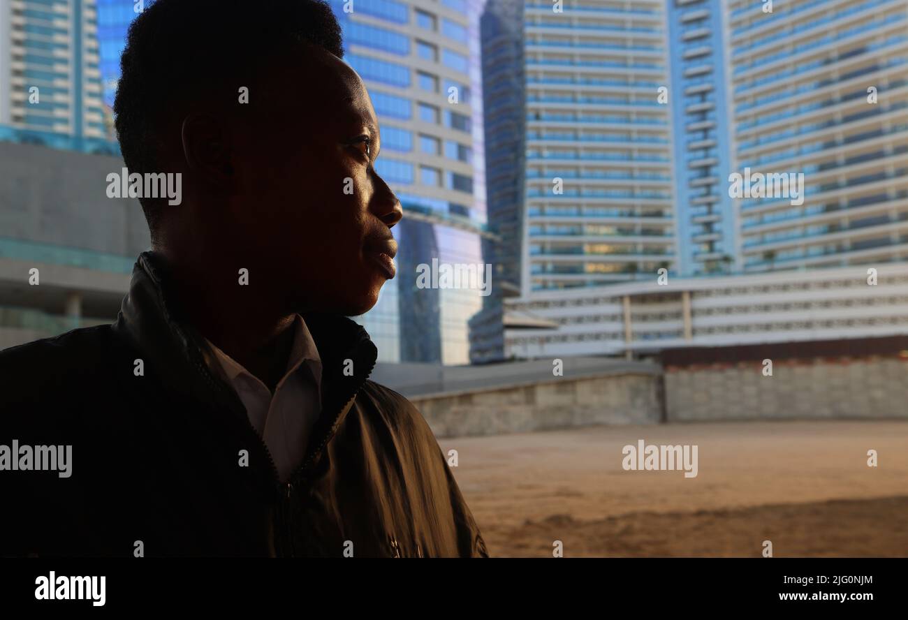 Dubai, Afrikaner,Jugendlicher, Auswanderer,  Schwarzer junger Mann blickt auf due Hochhäuser in der Business Bay in Dubai Downtown Stock Photo