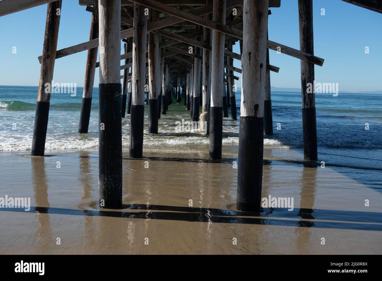 Underneath the wooden pier on Newport Beach, on the Pacific Ocean, in Southern California USA Stock Photo