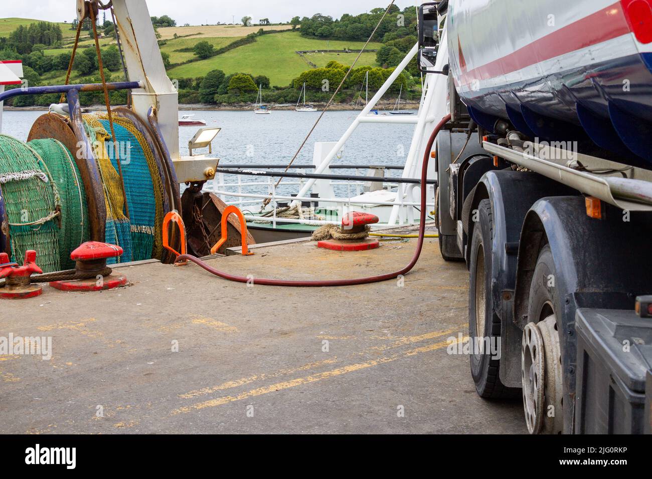 Fishing Trawler taking Diesel Fuel from road tanker. Stock Photo