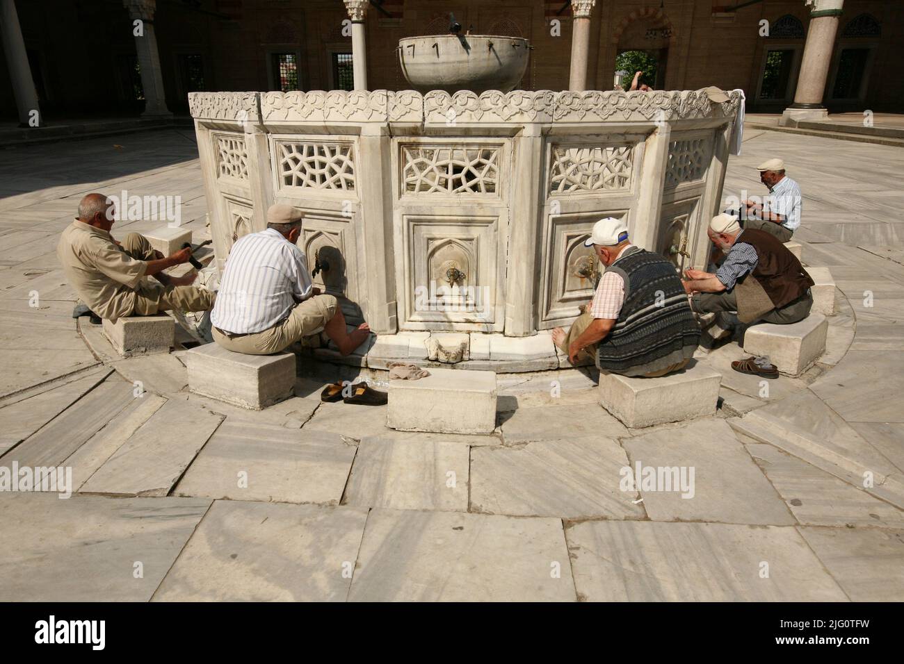 Kırkpınar (Turkish Oil Wrestling). Muslim men washing their feet before entering the mosque in the marble fountain in the courtyard of the Selimiye Mosque (Selimiye Camii) in Edirne, Turkey. The congregational prayer in the Selimiye Mosque marks the beginning of the 648th annual Kırkpınar Tournament on 2 July 2009. The annual tournament in Turkish oil wrestling traditionally starts with the Friday prayer (Jumu'ah) in the Selimiye Mosque designed by Ottoman imperial architect Mimar Sinan and built between 1568 and 1575. Ritual purification called wudu requiring Muslim people to wash their faces Stock Photo