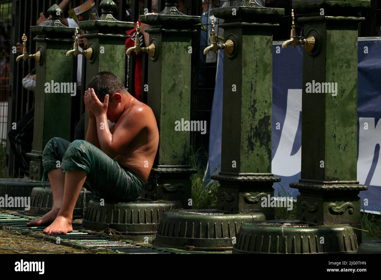 Kırkpınar (Turkish Oil Wrestling). Young wrestler cries after losing his fight sitting on the water pump during the 648th Kırkpınar Tournament in Edirne, Turkey, on 5 July 2009. Kırkpınar wrestlers compete stripped to the waist and smeared their bodies with olive oil. Stock Photo