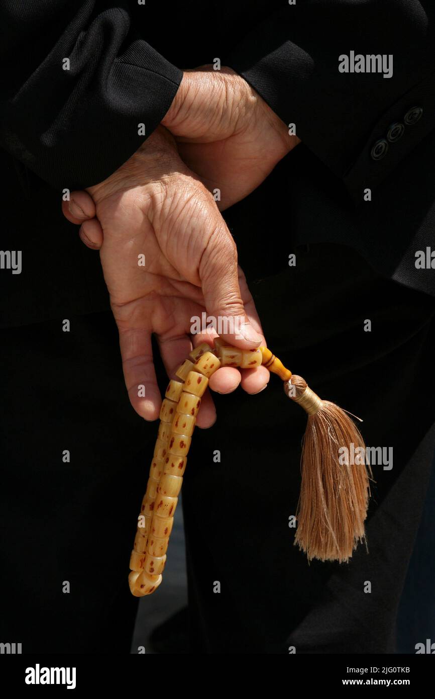 Muslim man holds the Muslim prayer beads, known as misbaha or tasbih tespih in the courtyard of the Selimiye Mosque (Selimiye Camii) in Edirne, Turkey. Stock Photo