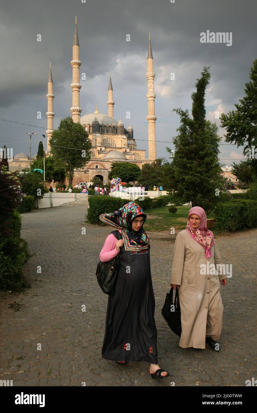 Turkish women wearing traditional clothes walked in front of the Selimiye Mosque (Selimiye Camii) in Edirne, Turkey. The mosque designed by Ottoman imperial architect Mimar Sinan was built between 1568 and 1575. Stock Photo