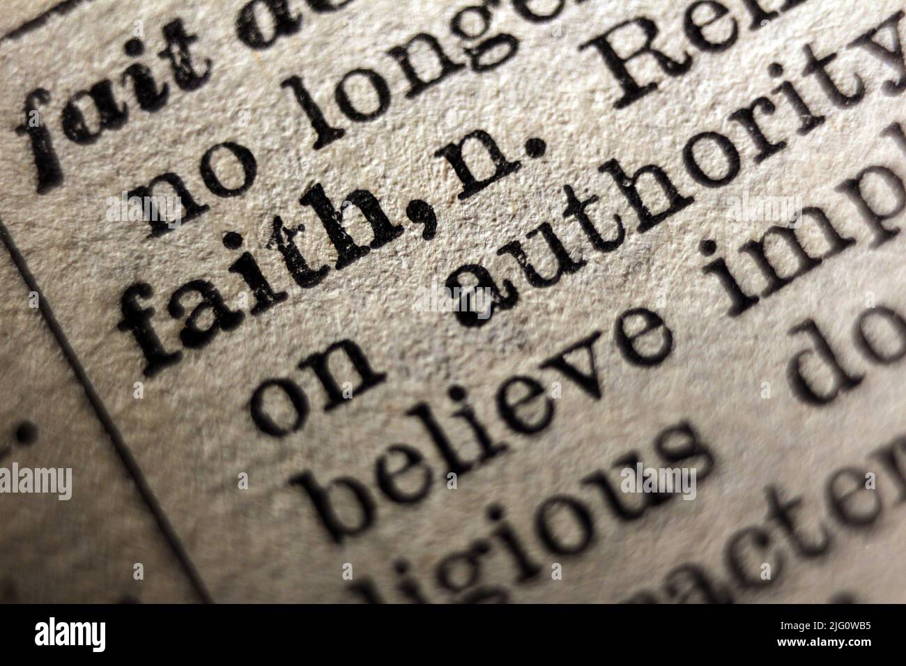 Word 'faith' printed on dictionary page, macro close-up Stock Photo