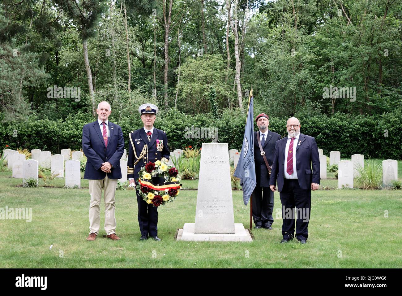 Sun 3rd July 22.At the the Belgian War Memorial Brookwood Military Cemetery with Belgian war graves in the background L to R: Paul McCue, author & military historian; Captain (Naval) Renaud Flamant Defence Attaché of the   Embassy of the Belgian Kingdom in the UK holding his Ambassadors wreath; Edward Jones, Artist Rifles Standard Bearer and Kevin Davis, Chair of the Brookwood Last Post Association. Stock Photo