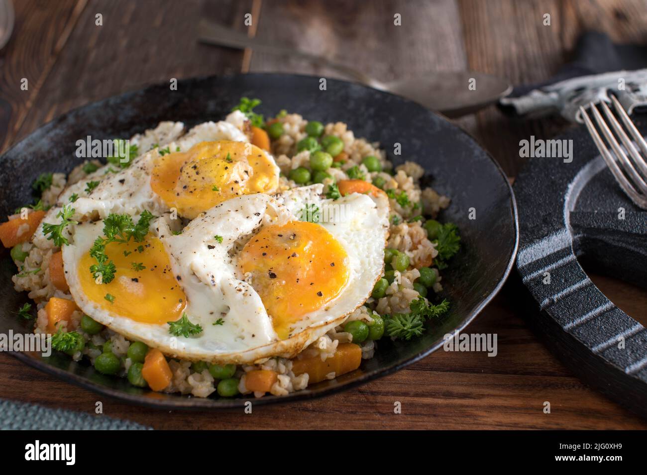 Bodybuilding meal with fried eggs, brown rice and vegetables Stock Photo