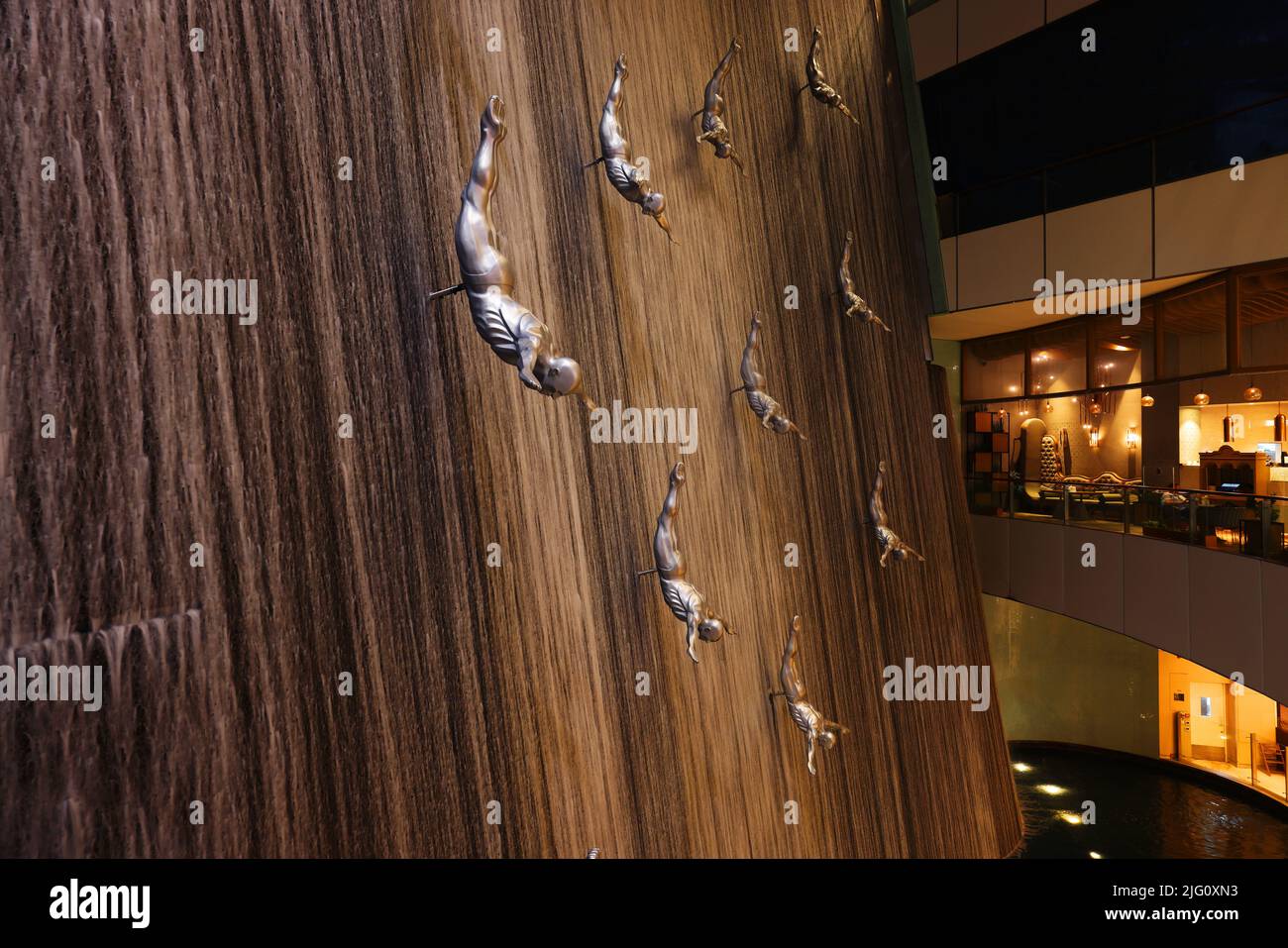 Wasserfall, Dubai Mall, Dubai, Einkaufszentrum, Moderne Kunst mit Klippenspringer oder Taucher in der Dubai Mall dem größten Einkaufszentrum der Welt Stock Photo