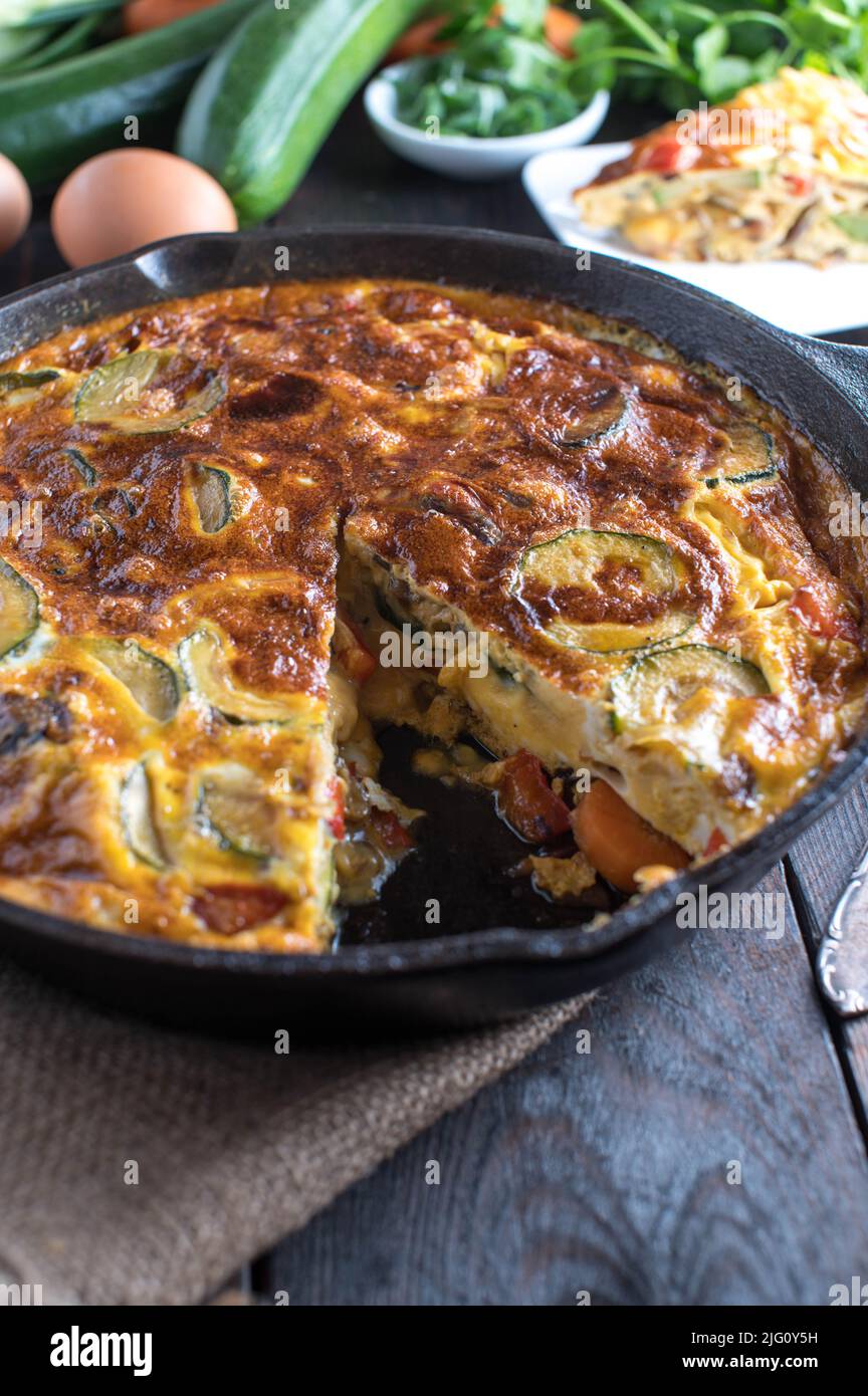 Healthy egg dish with a oven baked frittata with vegetables in a cast