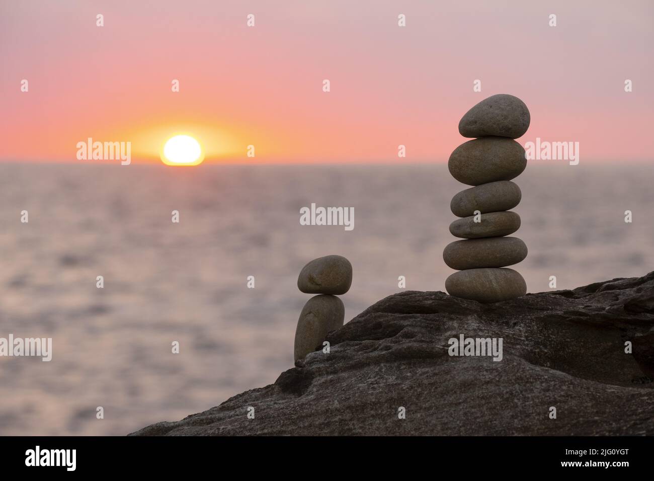 Stacked stone tower on the beach by the sea with the sunset out of ...