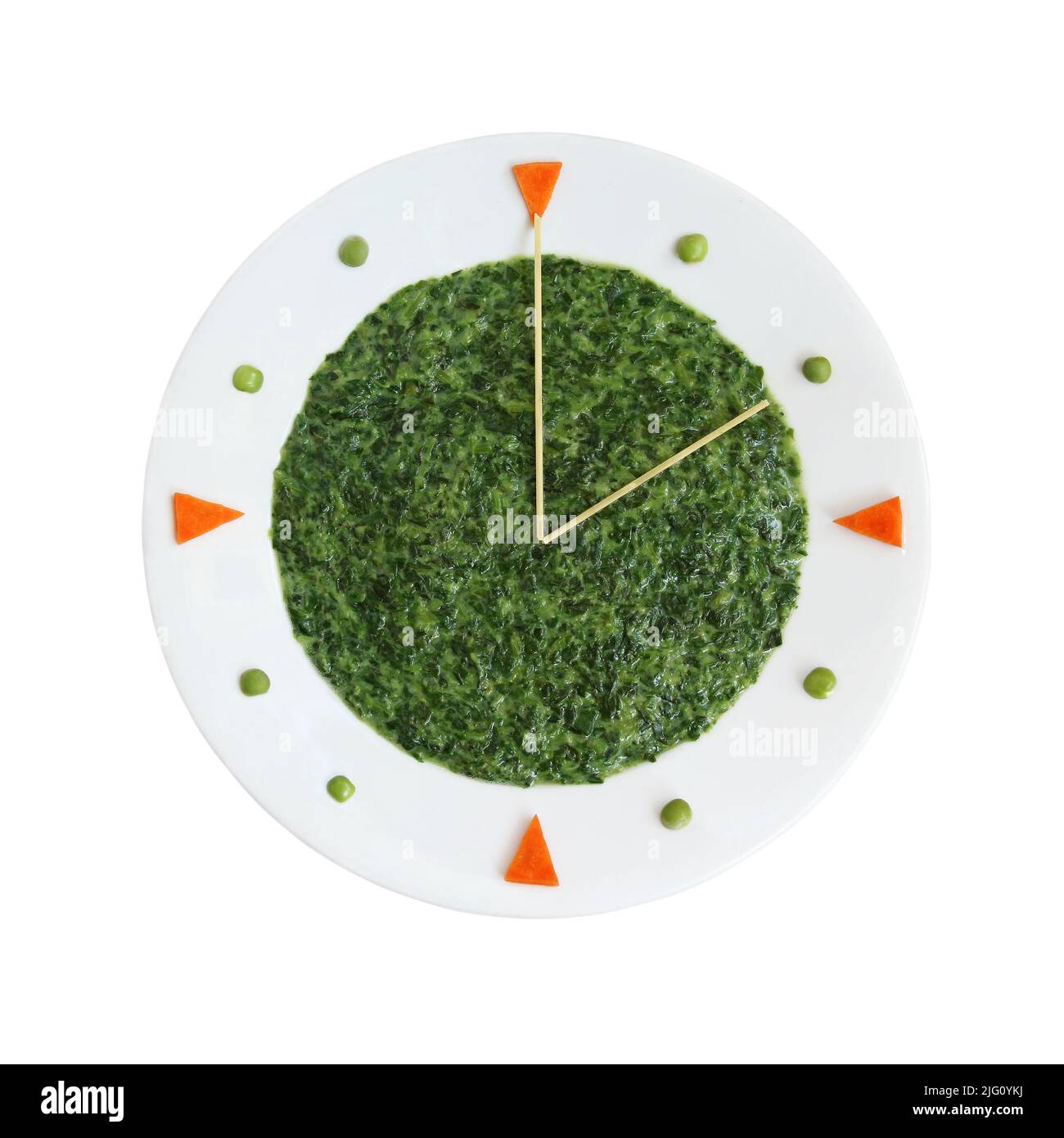 Food clock - plate with creamed spinach for health nutrition concept (manual focus on the spaghetti in the center) Stock Photo