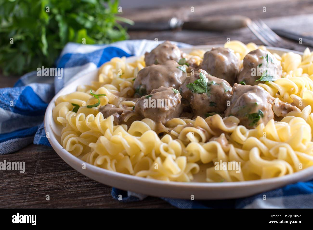 Pasta with swedish meatballs and cream sauce on a plate. Traditional 'Köttbullar' Stock Photo