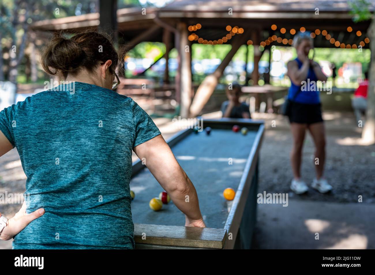 Camp councilor playing carpetball with a younger child Stock Photo Alamy