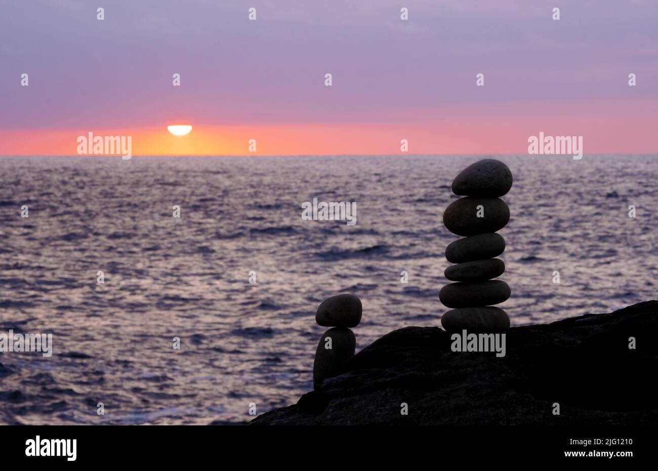 Stacked stone tower on the beach by the sea with the sunset out of ...