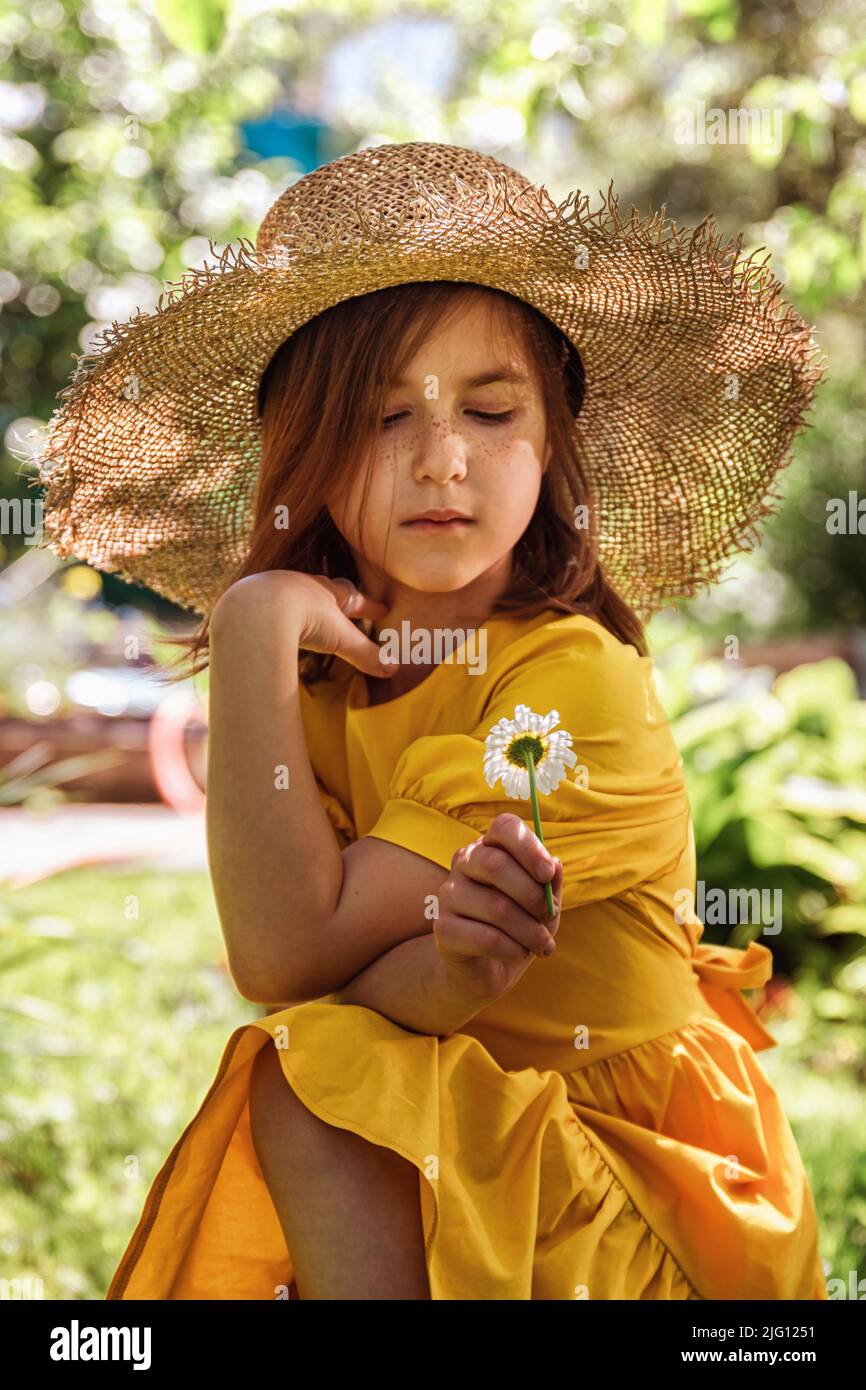 cute little girl in a yellow dress and straw hat walking Stock Photo ...