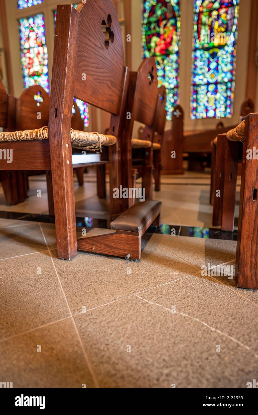 Ground level view of kneeling bench rows in a church used for praying