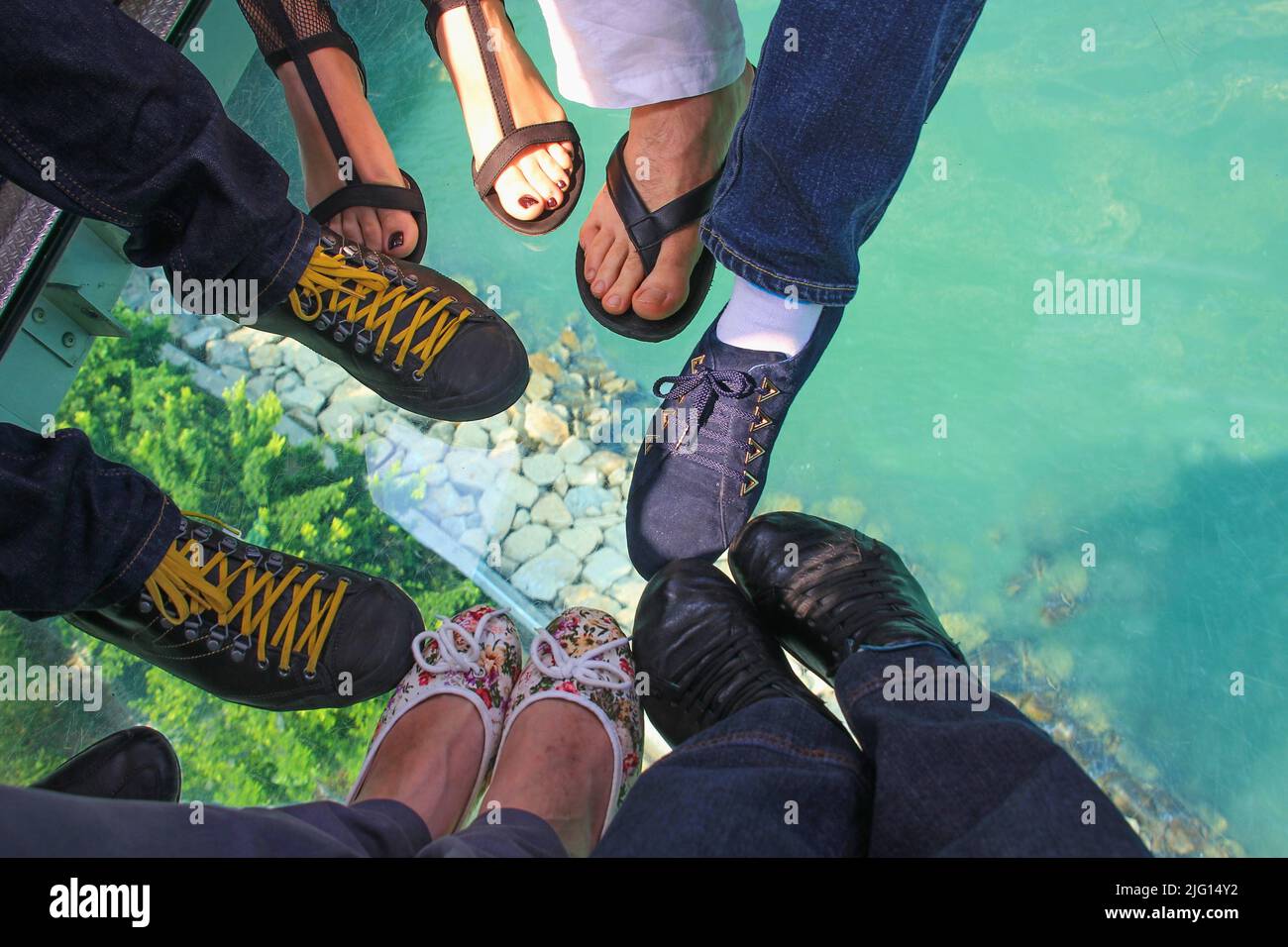 Top view to low section of travelers people standing on glass floor of crystal cabine of Hong Kong cableway visiting Lantau island with Giant Buddha Stock Photo