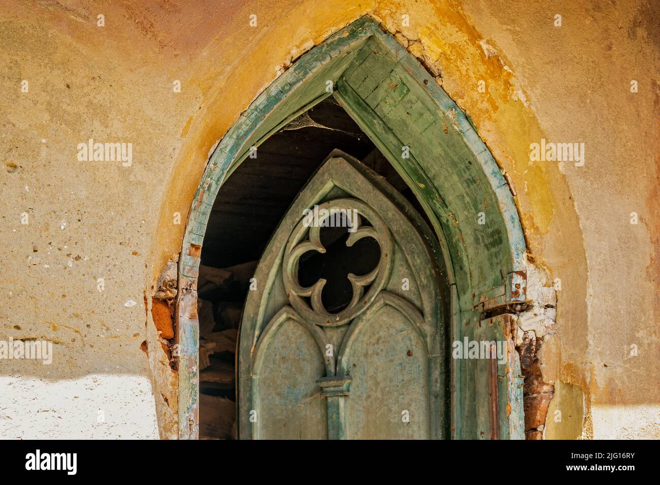 Open wooden gothic door at historical building focused on the wall