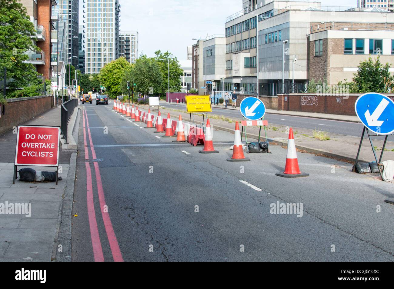 Works on a bridge reducing two lanes to single lane with red cones Stock Photo