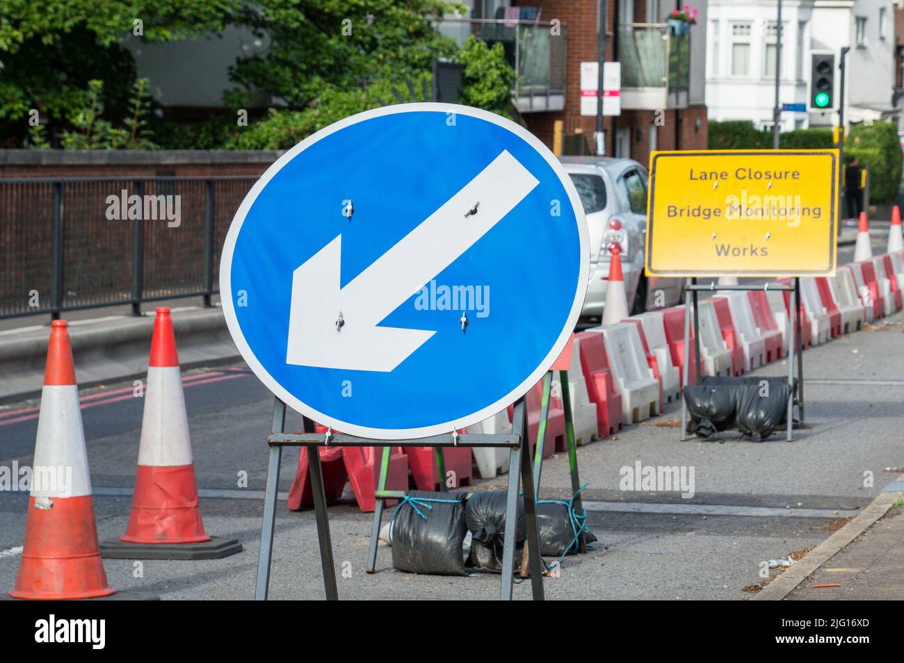 Works sign board asking to keep left to single lane Stock Photo