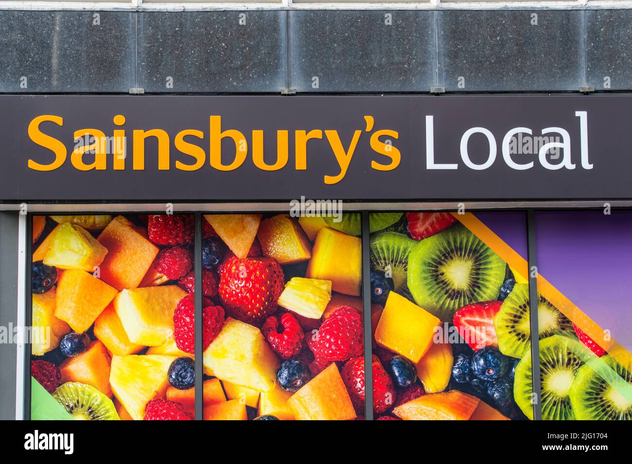 Sainsbury's local store windows filled with fresh cut fruits Stock