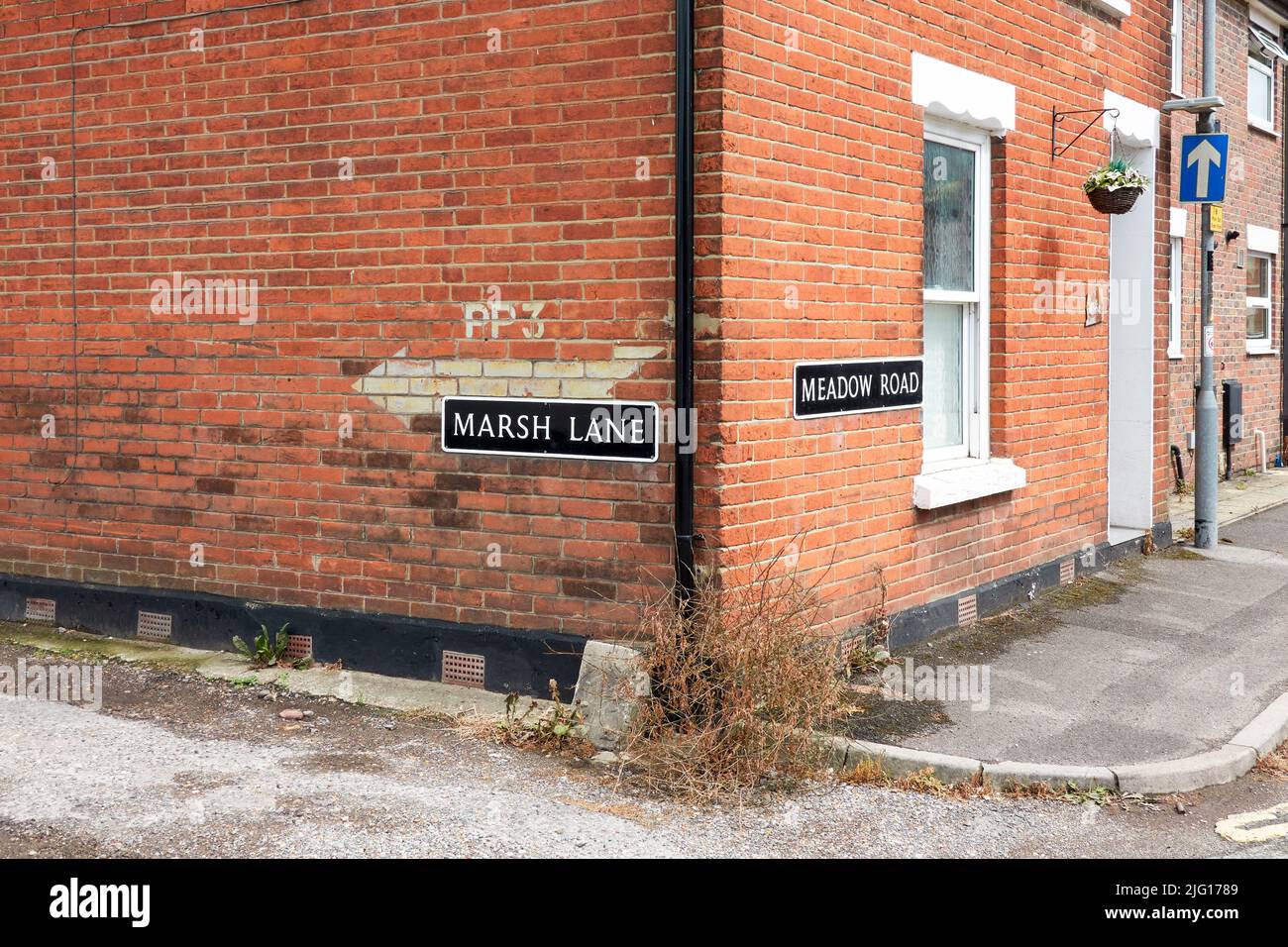 Street corner with road names on a red brick wall Stock Photo