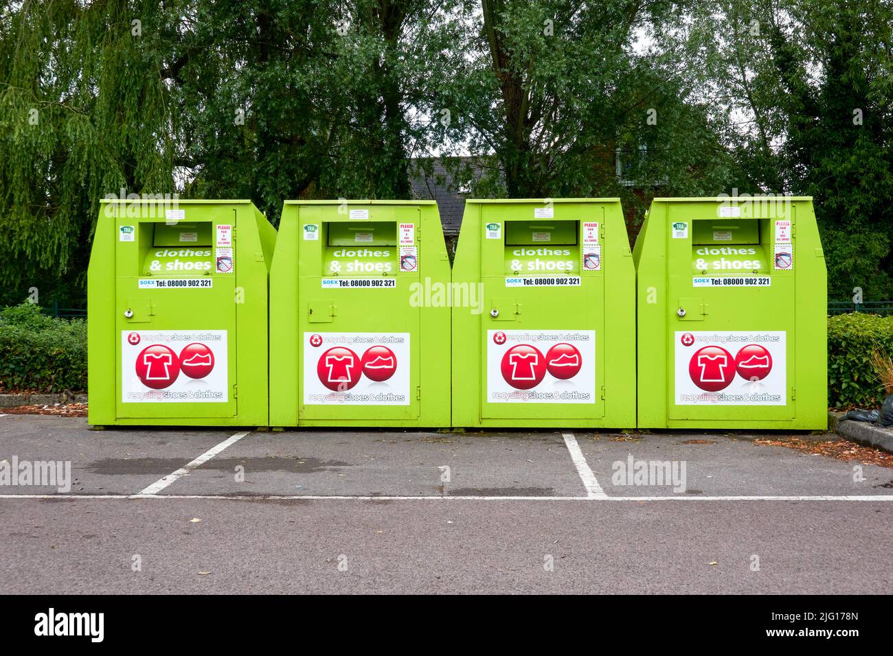 Row of four clothes and shoes metal recycling bins Stock Photo