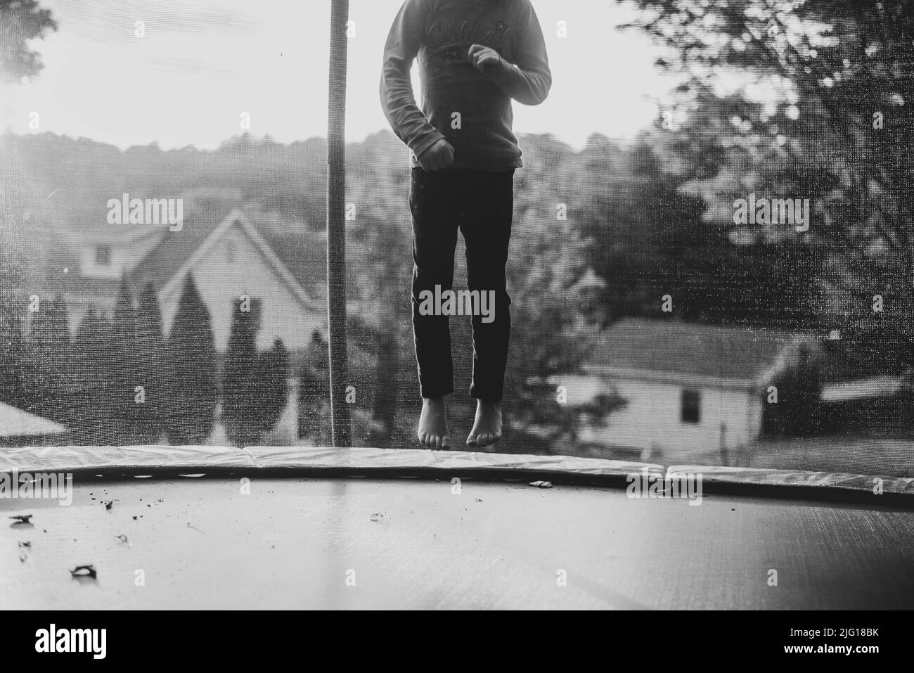 A seven year old girl child jumping on a trampoline. - Stock Image