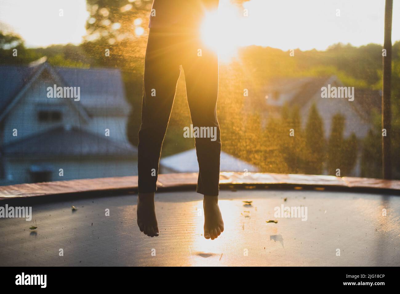 A seven year old girl child jumping on a trampoline. Stock Photo