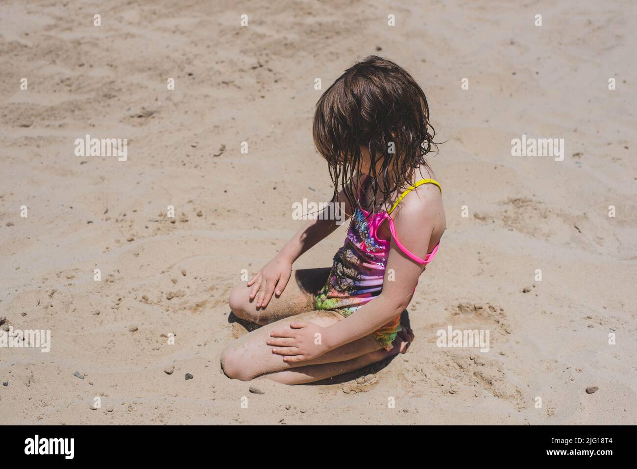 A little girl plays at a beach along a lake in Pennsylvania. Stock Photo