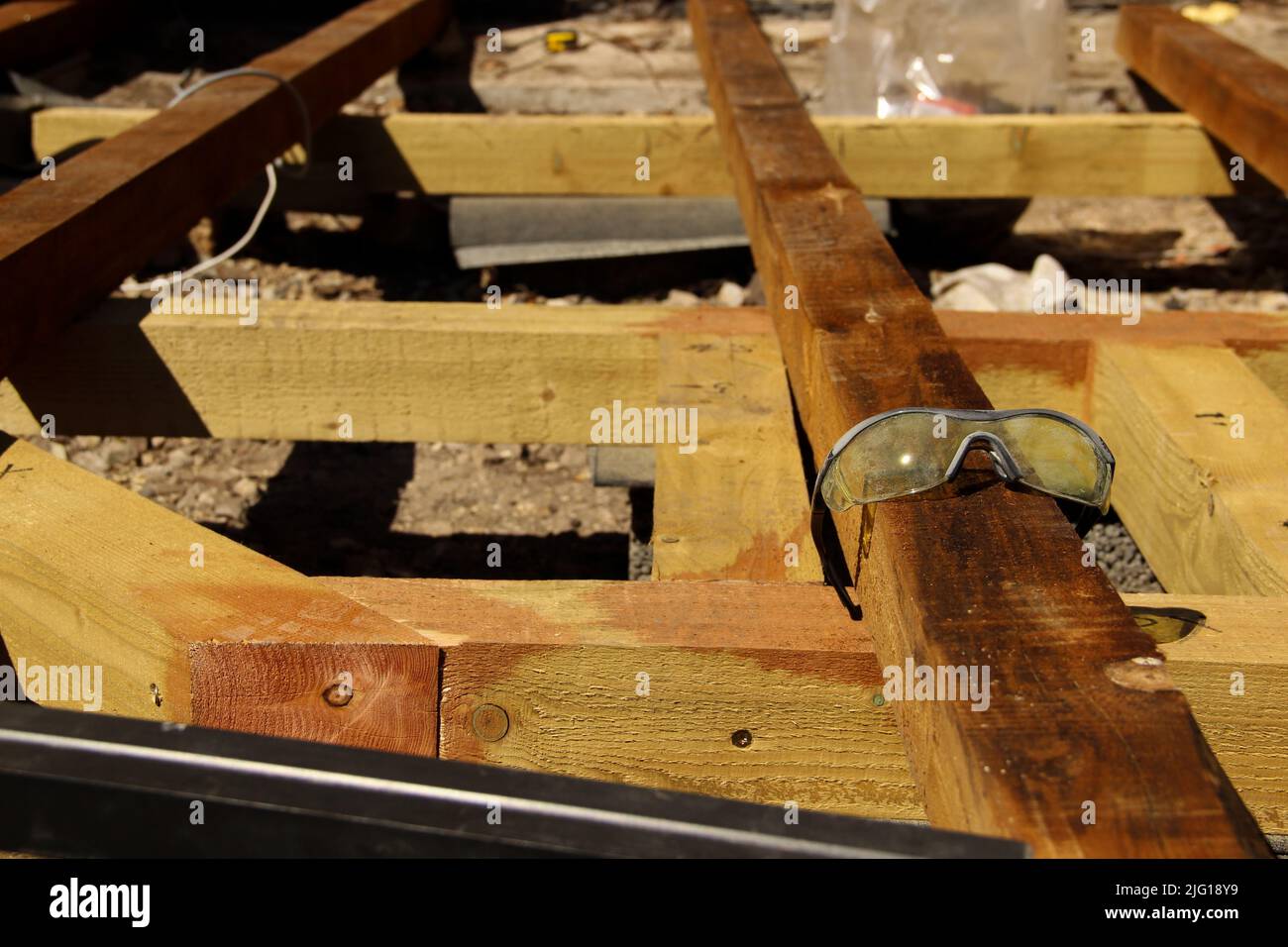 Plastic safety glasses. Used safety goggles lying on a beam. Stock Photo