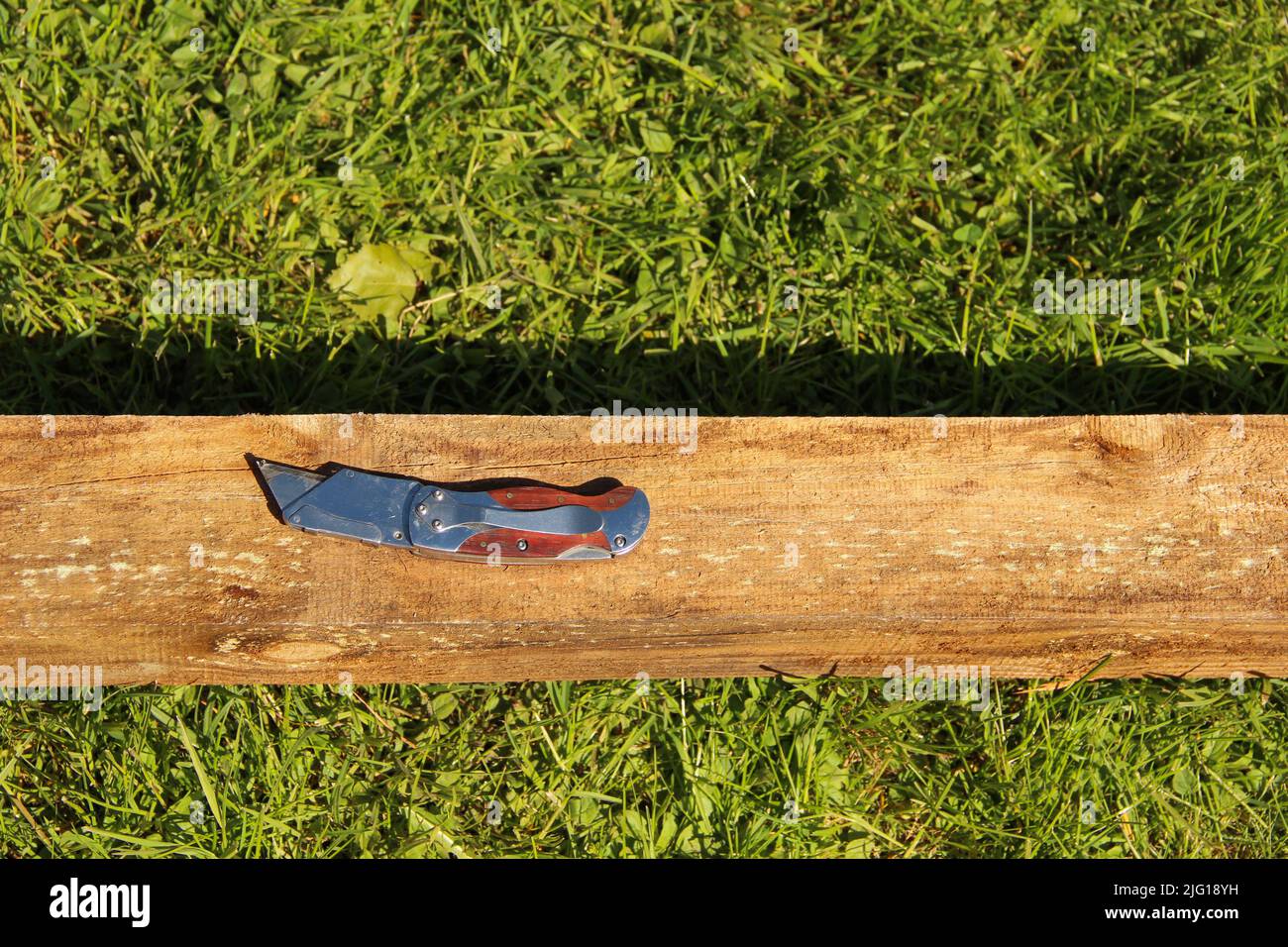 Construction knife over a wooden beam. Pocket knife Stock Photo Alamy