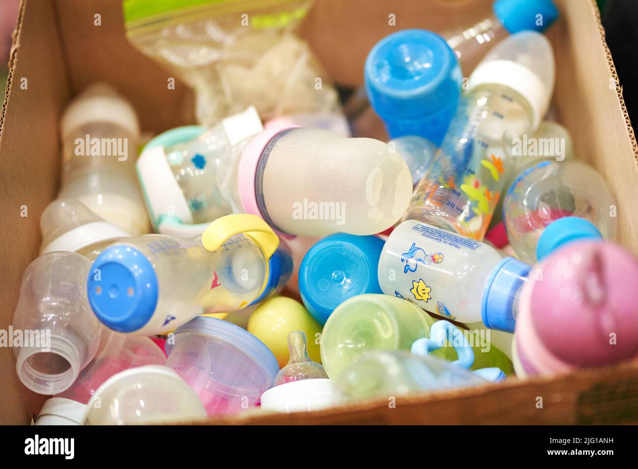 Box filled with baby bottles with rubber caps. Stock Photo