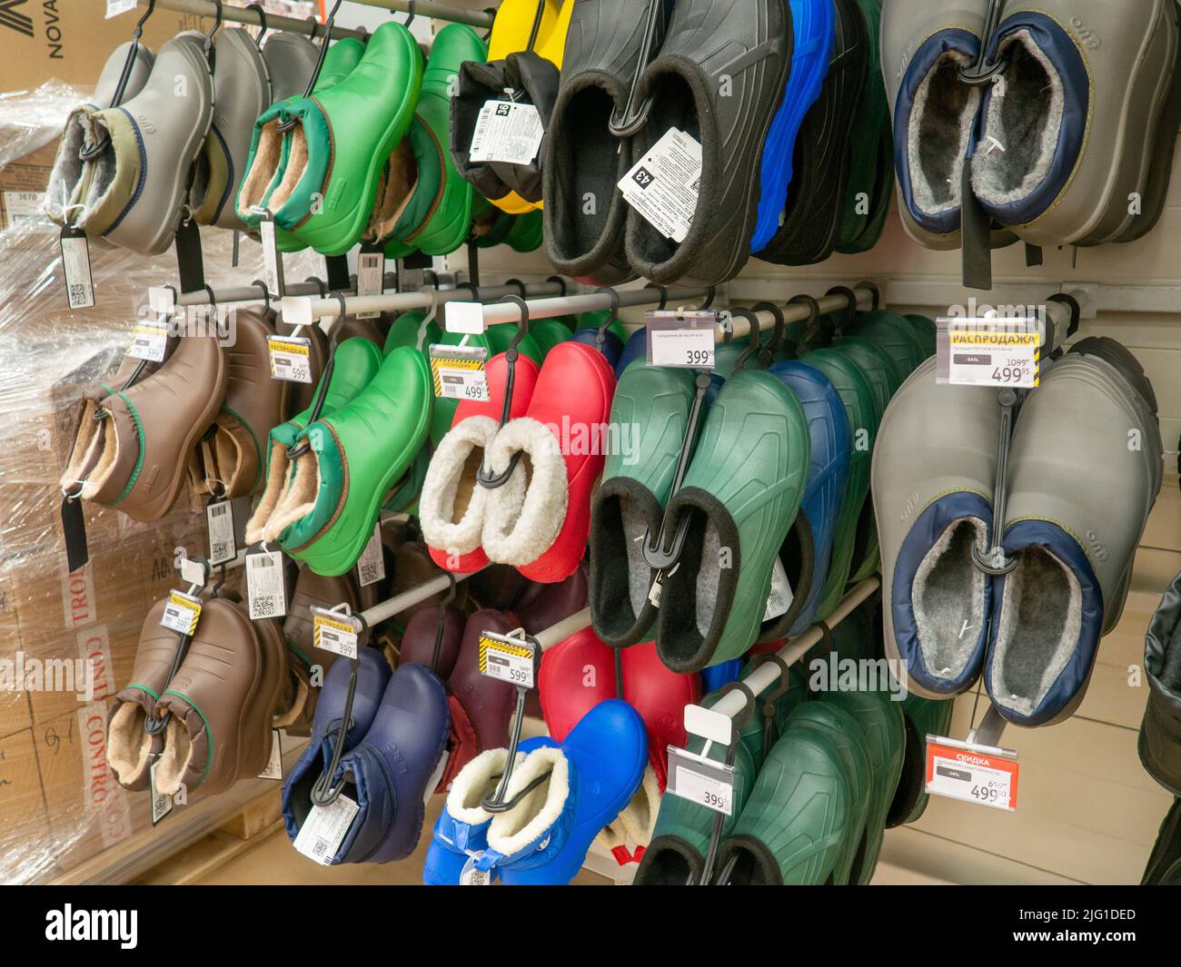 Shelves in the store. Galoshes. Laying out goods in a supermarket. Sale of shoes. Trade Stock Photo