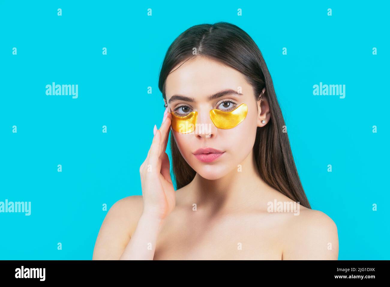 Eyes mask cosmetic patches woman face closeup. Woman applying golden eye patches. Close up portrait girl. Portrait of beauty woman with eye patches Stock Photo