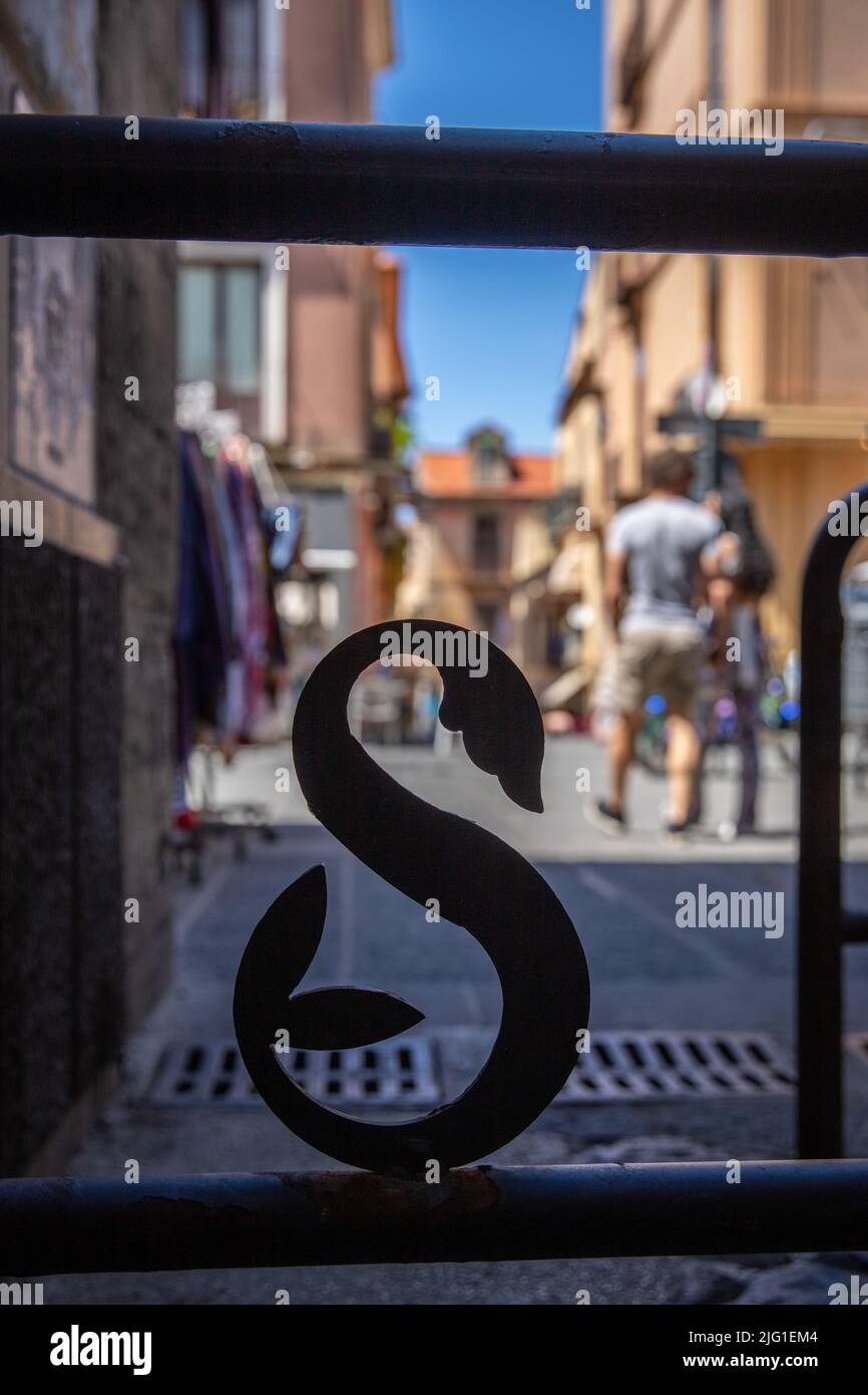 Fence shapes in a capital S (for Sorrento) with couple of tourists in the background (Via Antonino Sersale) Stock Photo