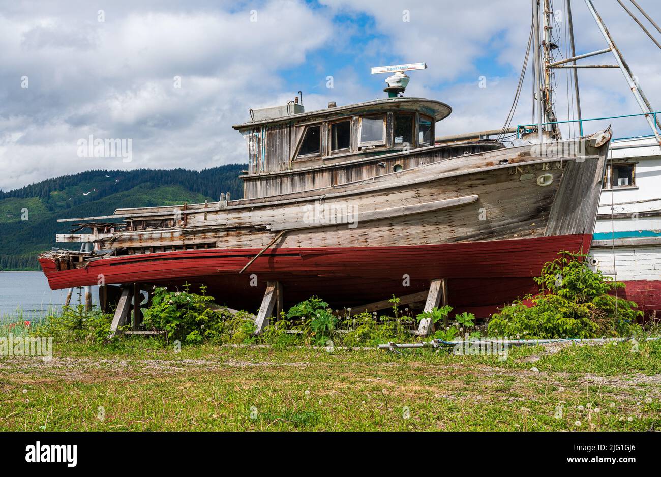 Hoonah, AK - 7 June 2022: Small abandoned fishing boats on the waterside at Icy strait Point near Hoonah Stock Photo