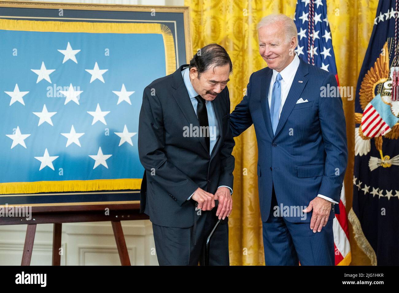 Washington, United States Of America. 05th July, 2022. Washington, United States of America. 05 July, 2022. U.S President Joe Biden, right, congratulates retired Spc. Dennis Fujii after presenting him with the Medal of Honor for his actions during the Vietnam War at a ceremony in the East Room of the White House, July 5, 2022 in Washington, DC Credit: Adam Schultz/White House Photo/Alamy Live News Stock Photo
