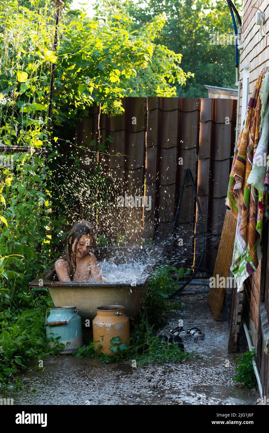 Little Girl Splashing Water Pool Garden Concept Summer outdoor Activities Stock Photo