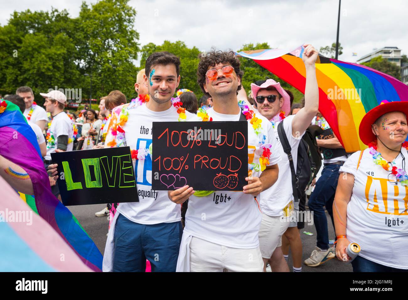 Young gay couple holding placards at Pride in London Stock Photo