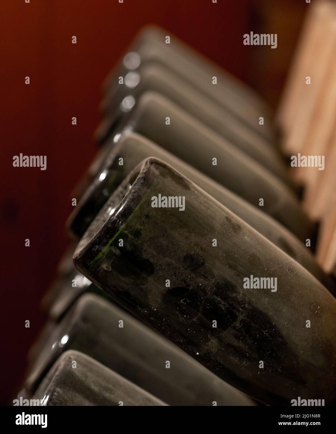 old, dusty wine bottles aging upside down in a wine cellar Stock Photo