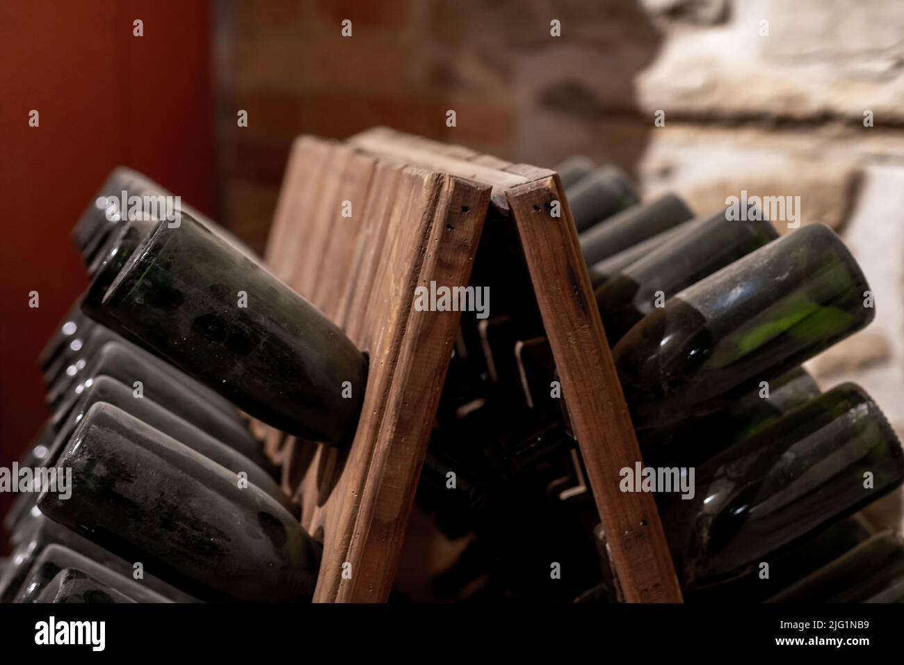 old, dusty wine bottles aging upside down in a wine cellar Stock Photo