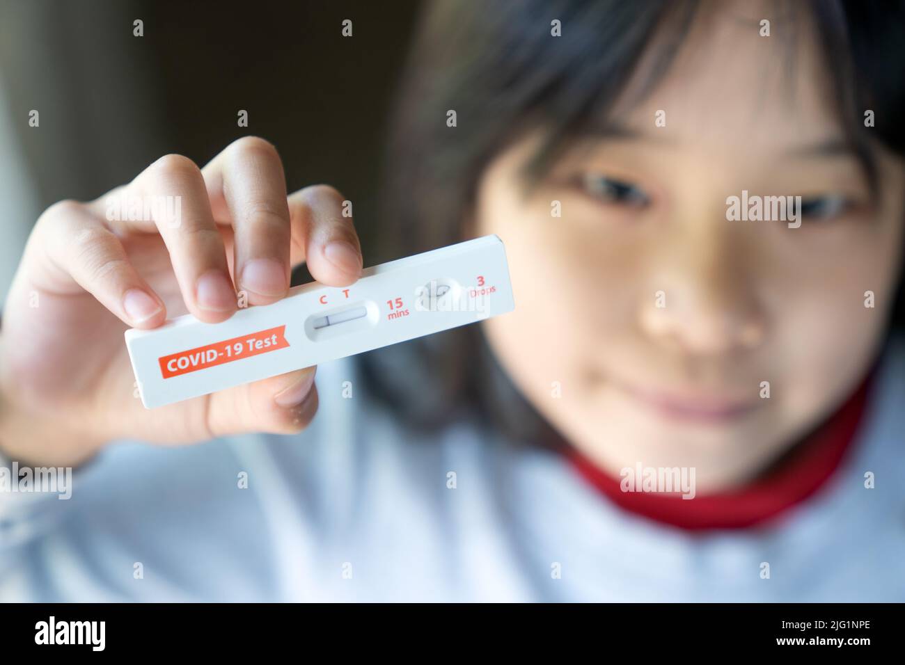 Little girl is showing negative results on rapid antigen test kit for