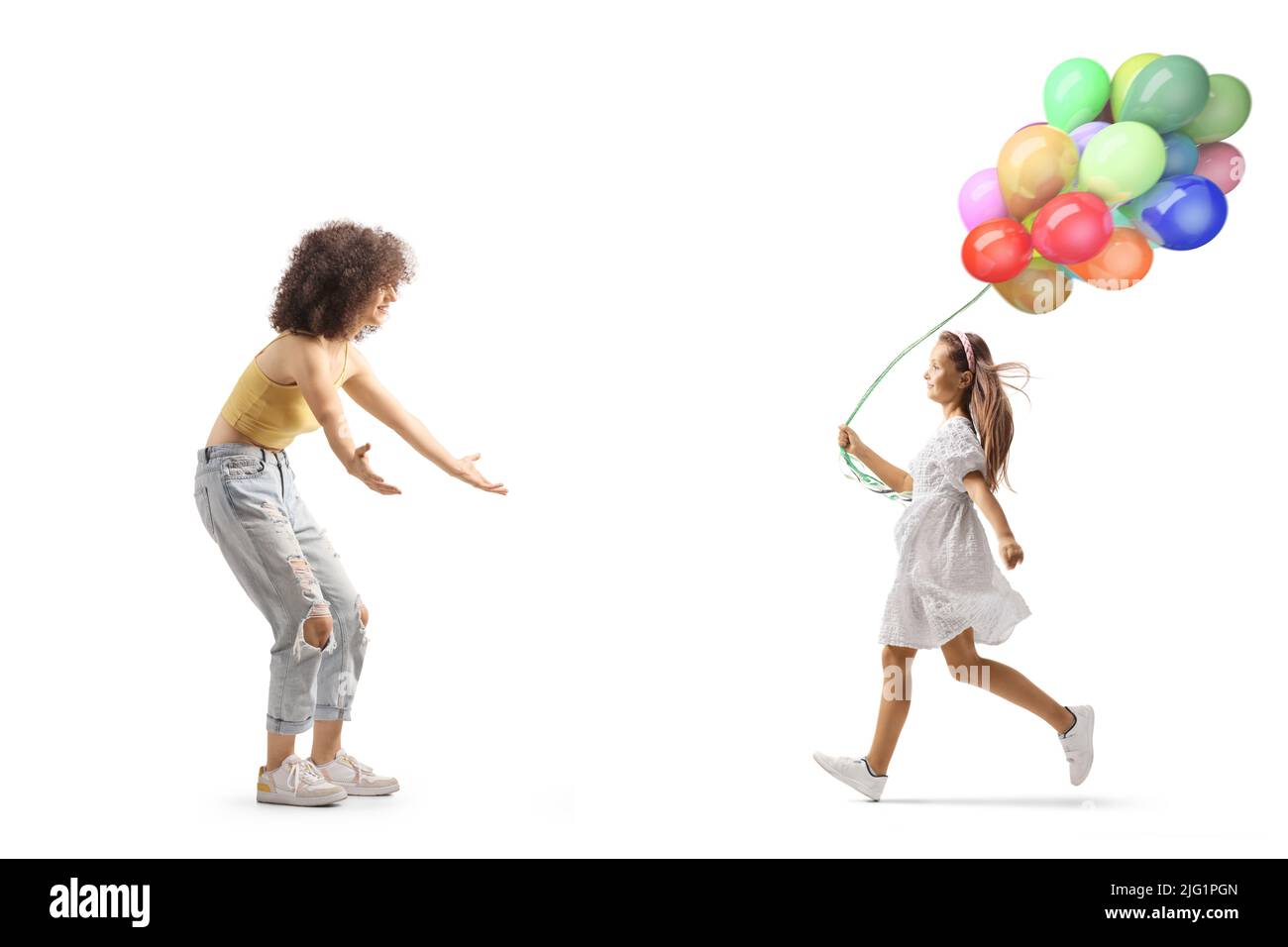 Full length profile shot of a girl with balloons running towards a young woman isolated on white background Stock Photo