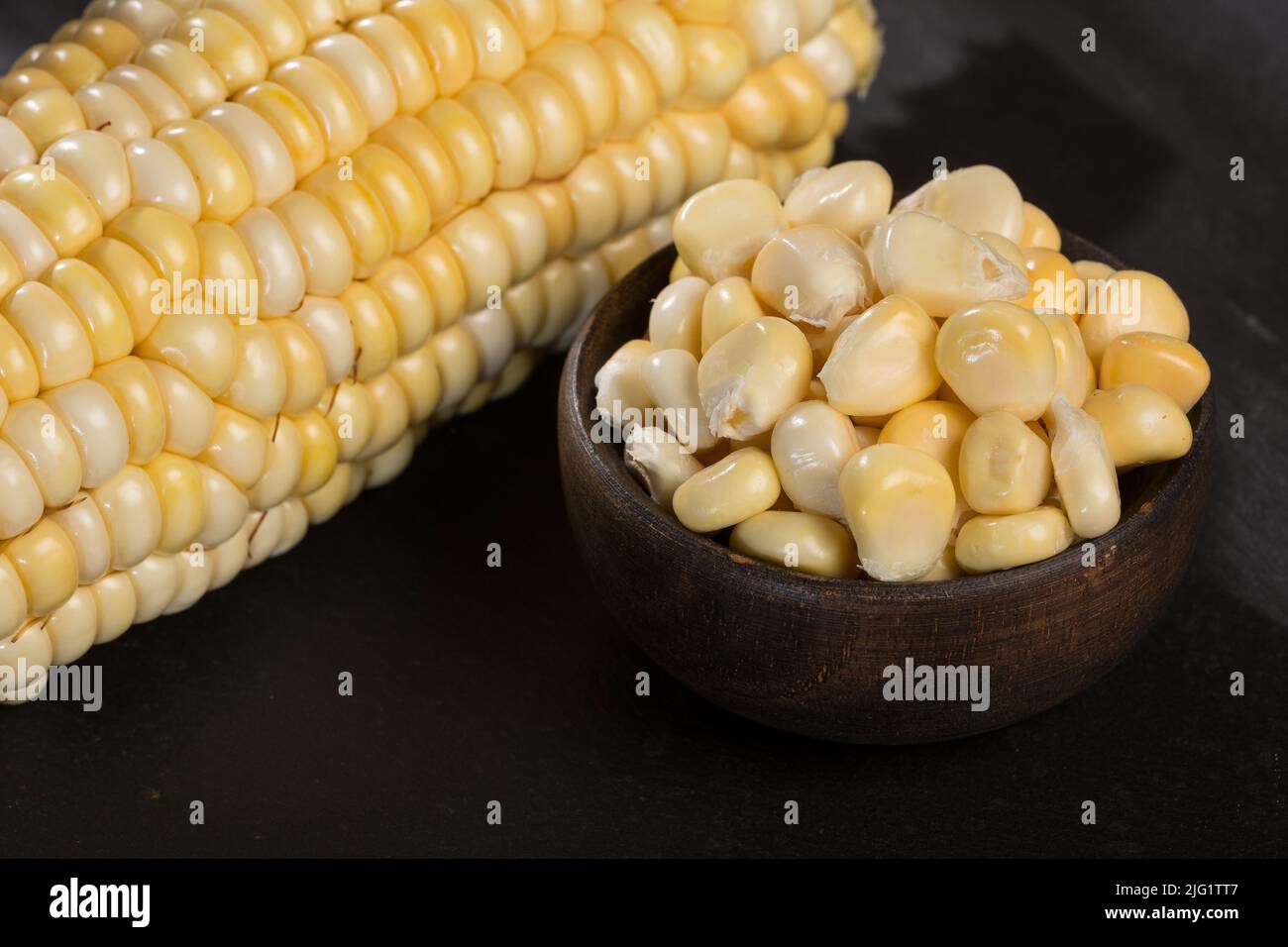 Zea mays - Wooden bowl with fresh corn kernels. Stock Photo