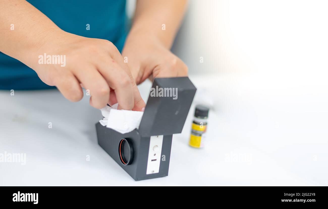 Female use tissue cleaning the refractometer after use and preparing to